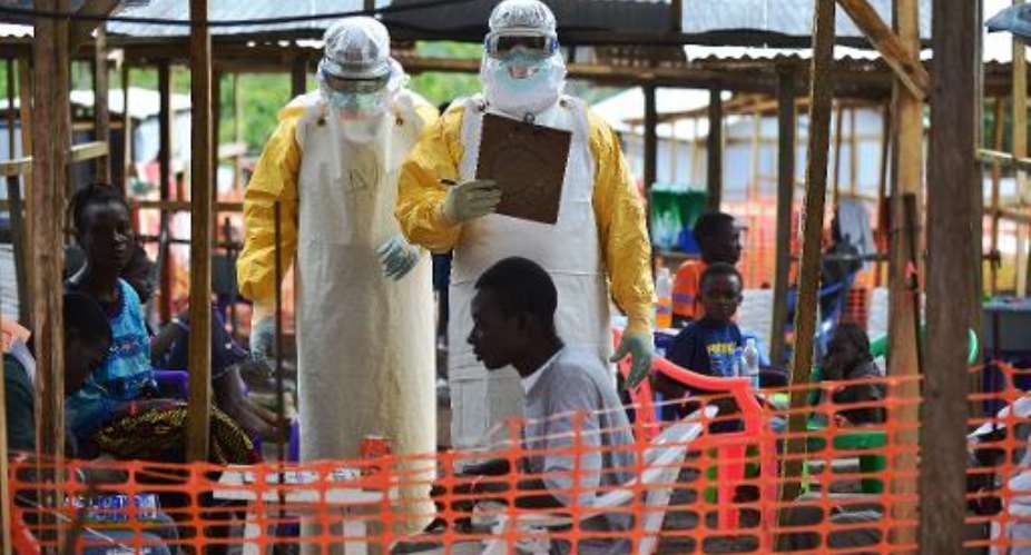 A Doctors without Borders (MSF) medical worker feeds a child suffering from Ebola at an MSF facility in Kailahun, eastern Sierra Leone on August 15, 2014.  By Carl De Souza (AFP)