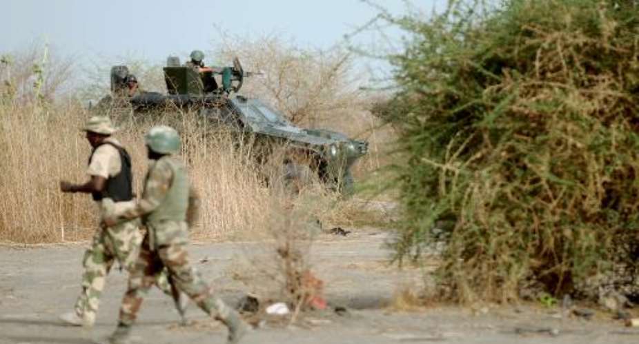Nigerian soldiers patrol in the north of Borno state close to a Boko Haram former camp on June 5, 2013 near Maiduguri.  By Quentin Leboucher (AFP/File)