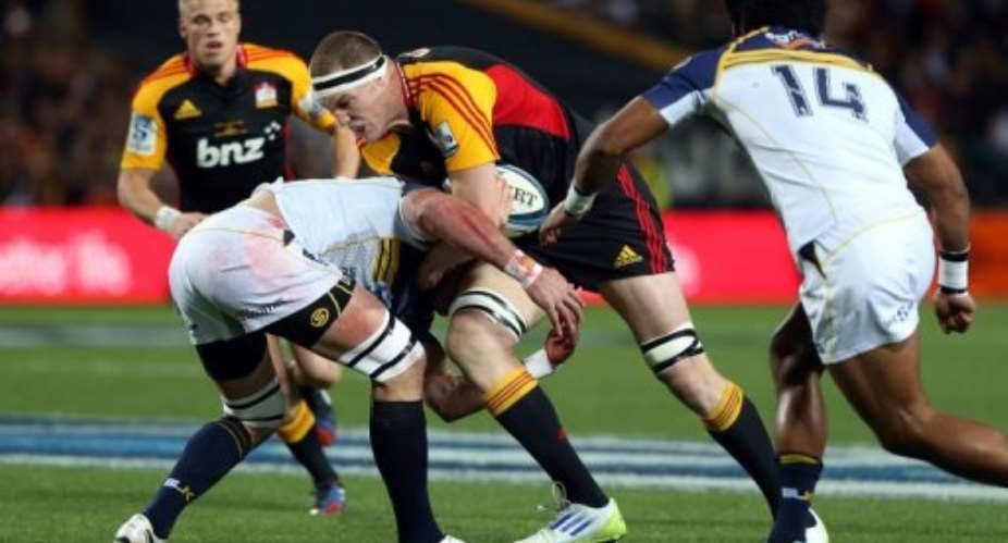 Chiefs Brodie Retallick is tackled by Brumbies Ben Mowen during their Super 15 rugby match on August 03, 2013..  By Michael Bradley AFP File