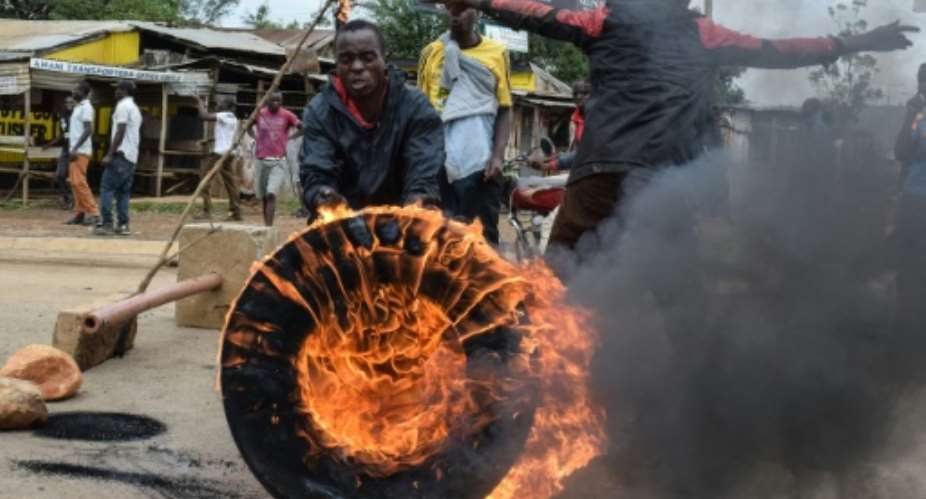 Supporters of opposition coalition the National Super Alliance NASA set a tire in fire in Kisumu, western Kenya, on October 13, 2017 during a protest against the re-run of the presidential election.  By Brian Ongoro AFPFile