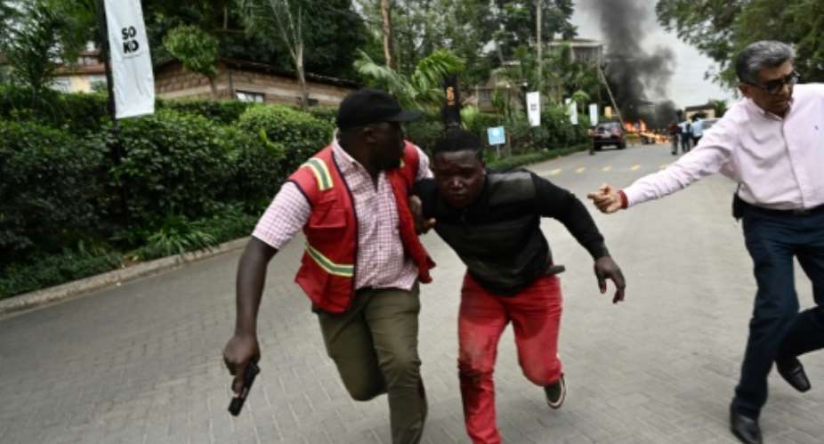 Survivors flee the scene of the attack on an upmarket hotel in the Kenyan capital.  By SIMON MAINA AFP