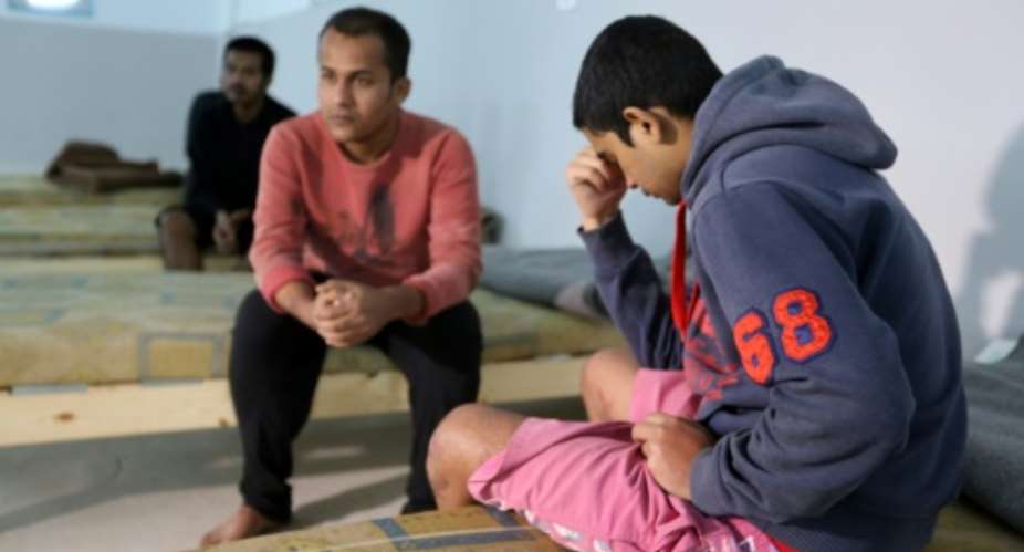 Survivors of a migrants shipwreck that killed around 60 people sit in a Tunisian shelter after being rescued at sea.  By FATHI NASRI AFP