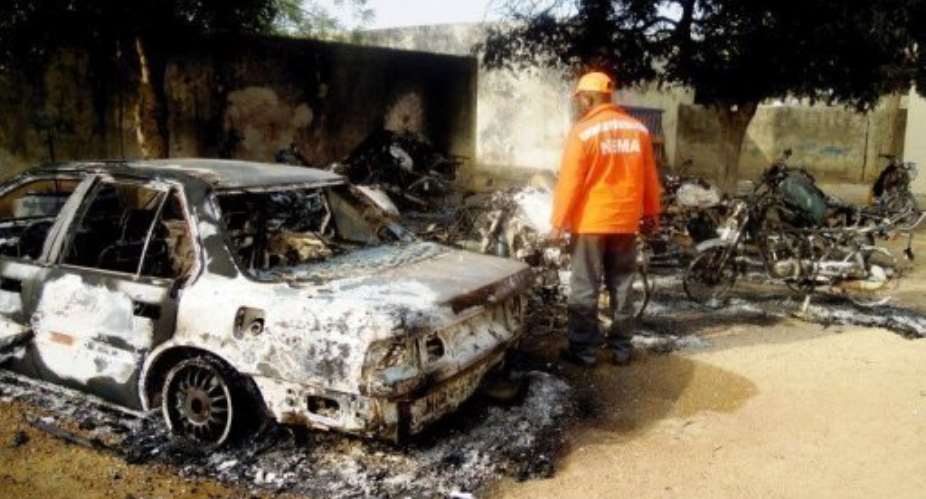 A rescue worker inspects the wreckage after explosions in Kano on January 21, 2012.  By Aminu Abubakar AFPFile
