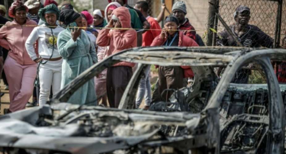 Suspects in the Johannesburg shooting torched two vehicles before fleeing.  By EMMANUEL CROSET (AFP)