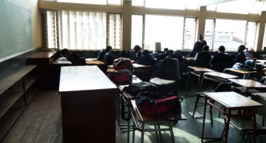 A group of pupils laugh, play or sleep in an empty geography class at St. Mark's High School in Mbabane on July 24.  By Johannes Myburgh AFPFile