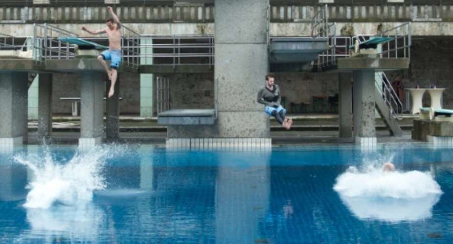 Swimmers jumping into a pool in Germany. Pools in the South African city of Cape Town are cracking down on splashing and surfer shorts in a bid to save water.  By Jrg Carstensen (DPA/AFP/File)