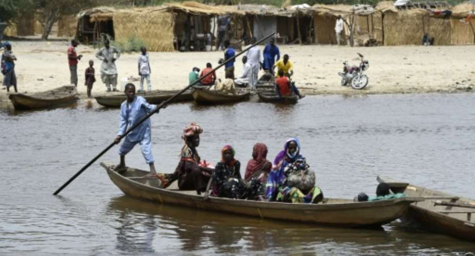 People cross a branch of Lake Chad on April 6, 2015, in N'Bougoua, which was attacked by Boko Haram.  By Philippe Desmazes AFPFile