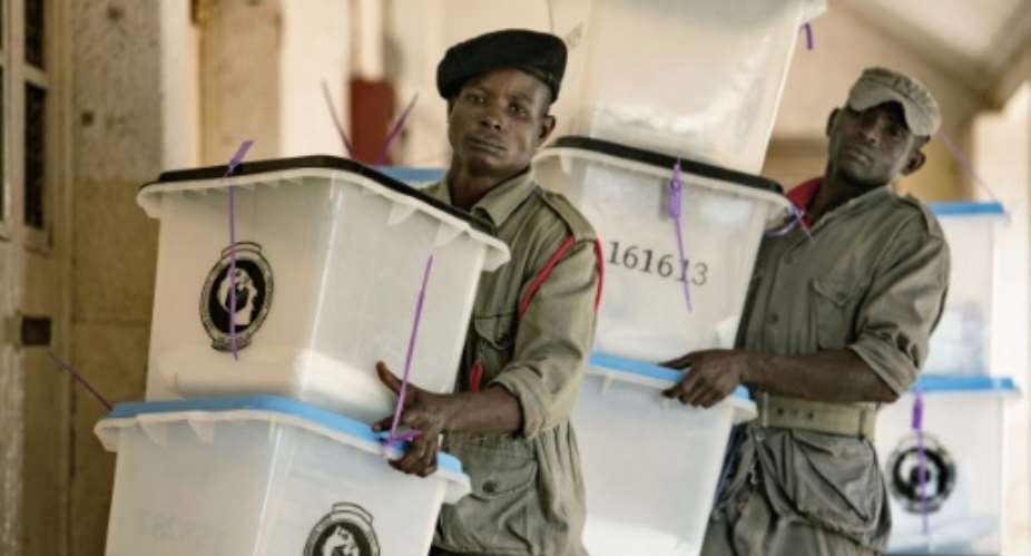 Security staff carry ballot boxes at a polling station in Tanzanias commercial capital Dar es Salaam on October 26, 2015.  By Daniel Hayduk (AFP)