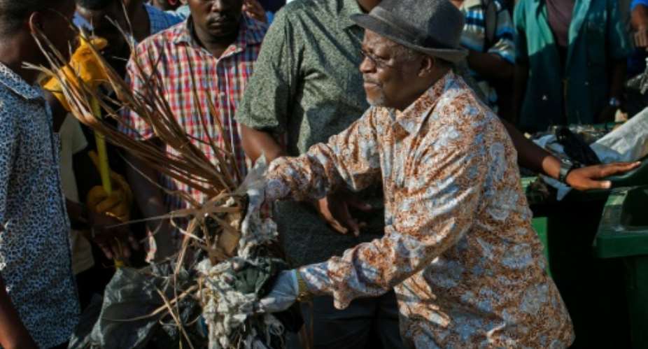 Tanzanian President John Magufuli joins a clean-up event outside the State House in Dar es Salaam on December 9, 2015.  By Daniel Hayduk AFP