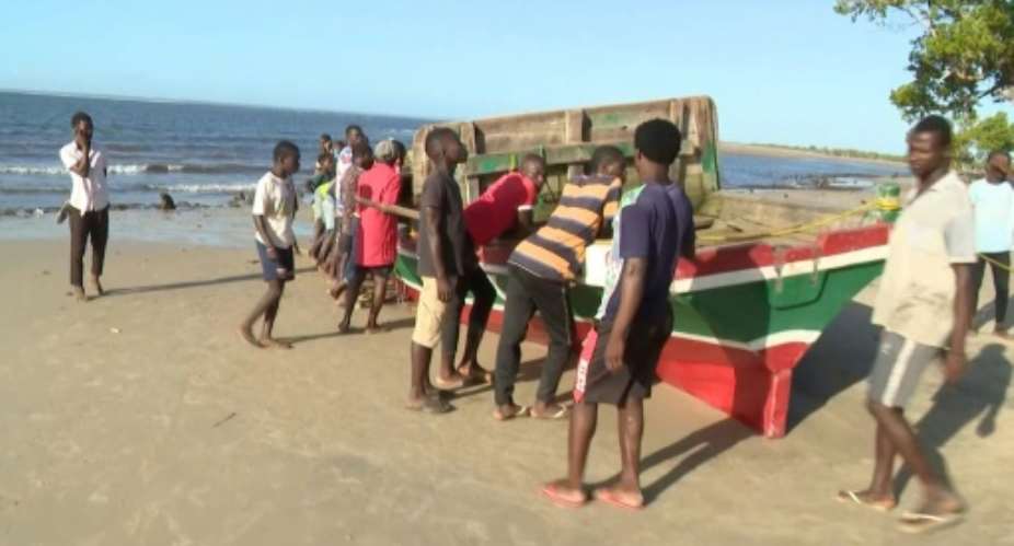 Television footage showed people gathered around the red and green wooden boat which had been pulled onto a beach.  By - TVMAFP