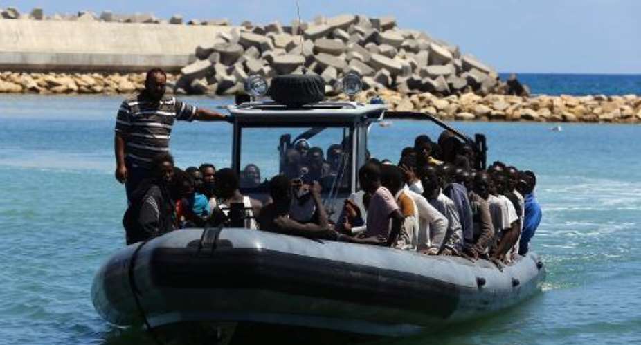 Libyan coastguards escort suspected illegal migrants after their boat started to sink east of Tripoli, on July 17, 2014.  By Mahmud Turkia AFP