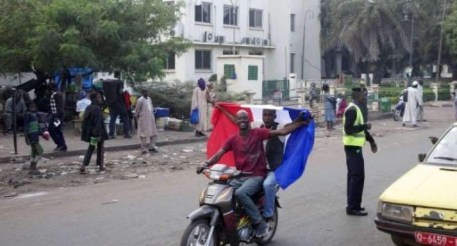 Malian people wave a French national flag on a scooter on January 12, 2013 in Bamako.  By Habibou Kouyate AFP