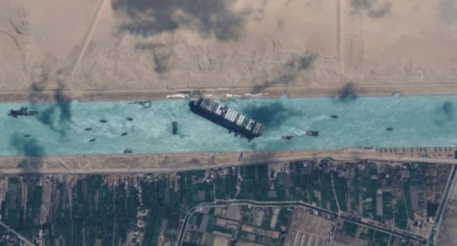 The 200,000-tonne MV Ever Given shown in satellite imagery released by Maxar Technologies got diagonally stuck in the Suez Canal in a sandstorm on March 23, 2021, triggering a mammoth six-day-long effort to dislodge it.  By - Satellite image 2021 Maxar TechnologiesAFPFile