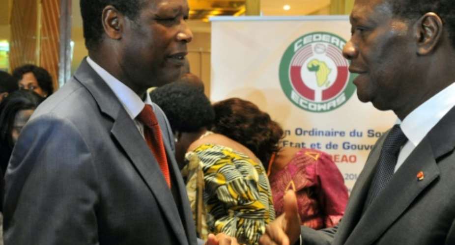 The African Union's former envoy on Mali, Pierre Buyoya, pictured left at a West African summit in Ivory Coast in March 2014. To the right is Ivorian President Alassane Ouattara.  By ISSOUF SANOGO AFP