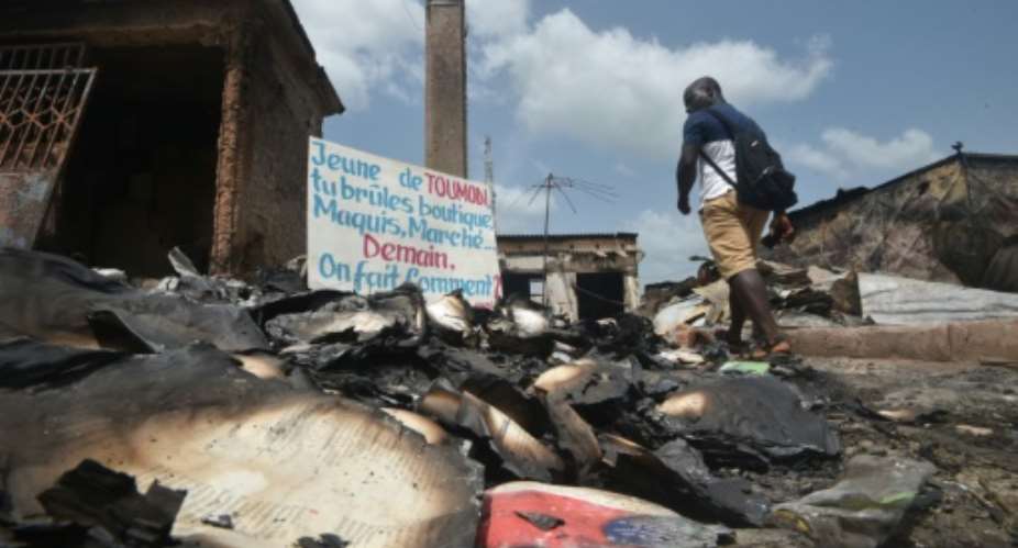 The aftermath of violence in the central Ivorian town of Toumodi. The sign says: 'Youth of Toumodi, you burn shops, restaurants, markets... tomorrow, how do we get by?'.  By SIA KAMBOU AFP