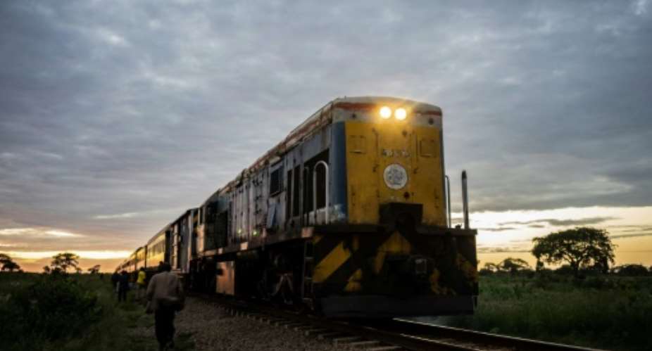The commuter train known as the 'Freedom Train' nears a station in Cowdray Park township, Bulawayo, as dawn light rises on a late January day.  By Zinyange Auntony AFP