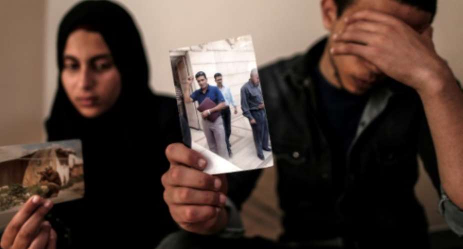 The daughter and son pictured April 2019 of Zaki Mubarak, whose body was transferred to Cairo after Ankara said he had committed suicide in prison, hold his picture during an interview in their family home.  By MAHMUD HAMS AFPFile