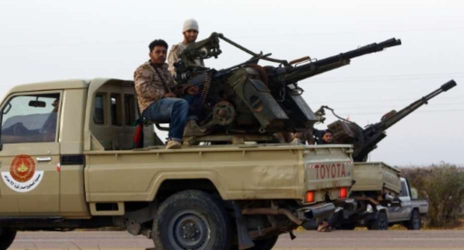 Members of a brigade loyal to Libya Dawn, an alliance of Islamist-backed militias, sit on a pick up truck mounted with a machine gun on March 15, 2015 in Libya's coastal city of Sirte.  By Mahmud Turkia AFPFile