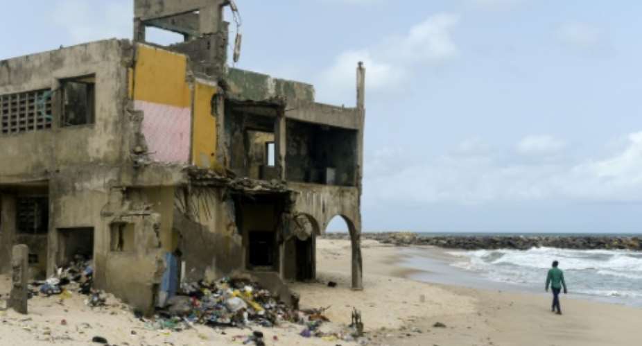 The shore-hugging Alpha Beach road has disappeared under the waves and apartment blocks built with prized ocean views just 10 years ago are now occupied only by squatters.  By PIUS UTOMI EKPEI AFP
