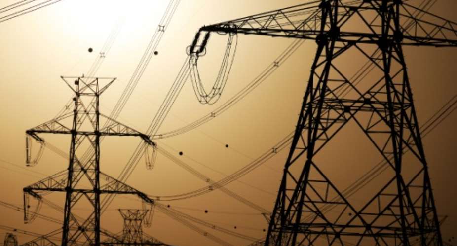 The sun sets behind overhead power lines in Kuwait City as the government requested citizens to ration their electricity usage amid soaring temperatures.  By YASSER AL-ZAYYAT (AFP)
