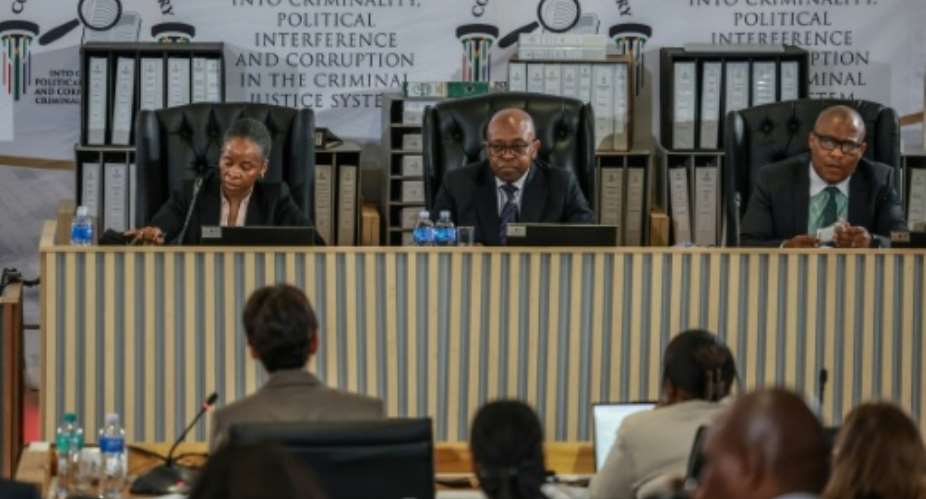 The three-person panel is headed by former Constitutional Court judge Mbuyiseli Madlanga (centre) and sits in the capital, Pretoria.  By PHILL MAGAKOE (AFP)