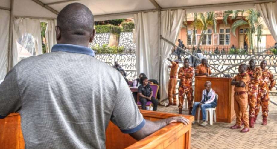The trial of Christopher Okello Onyum (4th right) was held in a specially erected tent to accommodate spectators.  By Stuart Tibaweswa (AFP)