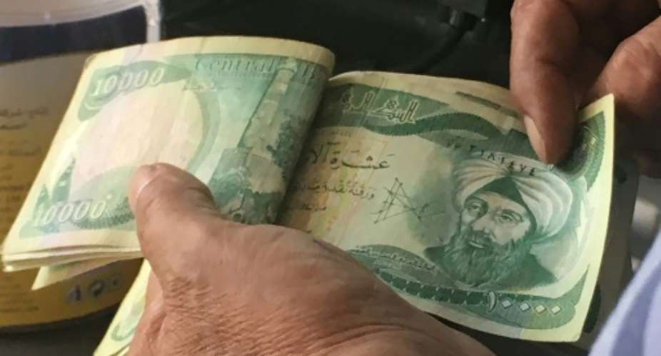 The United States is sanctioning seven financiers who allegedly helped funnel money to the Islamic State group -- seen here are 10,000-dinar banknotes in Iraq.  By Ali CHOUKEIR AFPFile