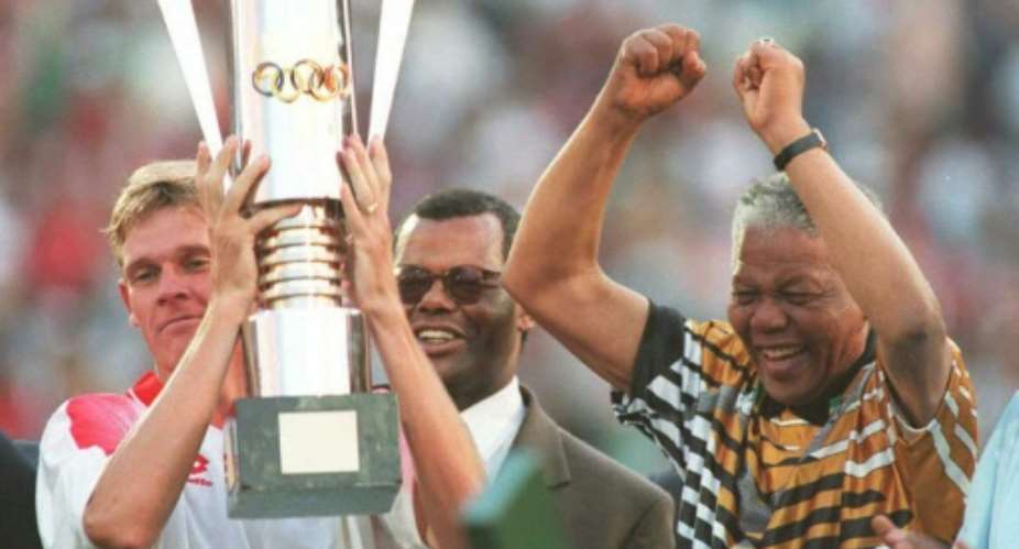 Then South Africa president Nelson Mandela R celebrates as captain Neil Tovey L holds the Africa Cup of Nations trophy after defeating Tunisia in the 1996 final.  By Mykel NICOLAOU AFPFile