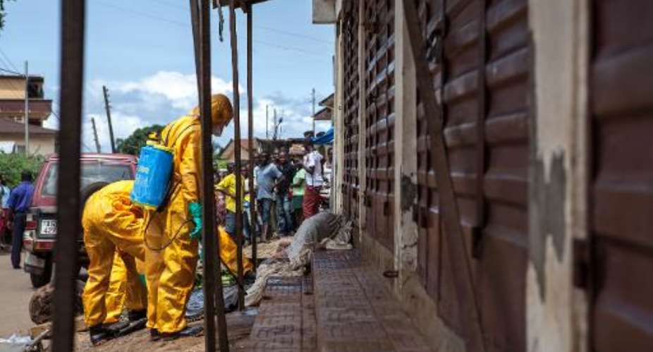 Volunteers pick up bodies of people who died of the Ebola virus, on October 8, 2014 in Freetown.  By Florian Plaucheur AFPFile