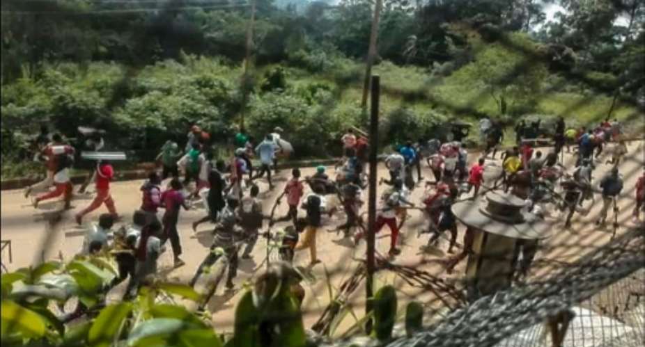 This frame grab taken from video footage on Monday shows crowds fleeing with items after they stormed a United Nations compound.  By Ushindi Mwendapeke Eliezaire AFPFile