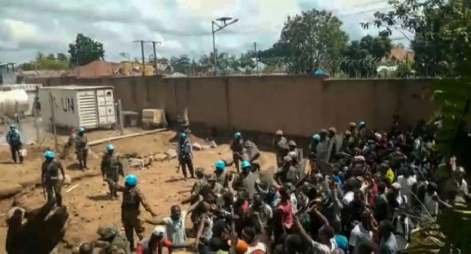 This frame grab taken from video footage shows crowds as they confront United Nations UN peackeepers in a UN compound on the outskirts of the eastern DRCongo town of Beni on November 25, 2019: protesters accused the UN troops of failing to protect them from armed militias who have killed hundreds.  By Ushindi Mwendapeke Eliezaire AFP