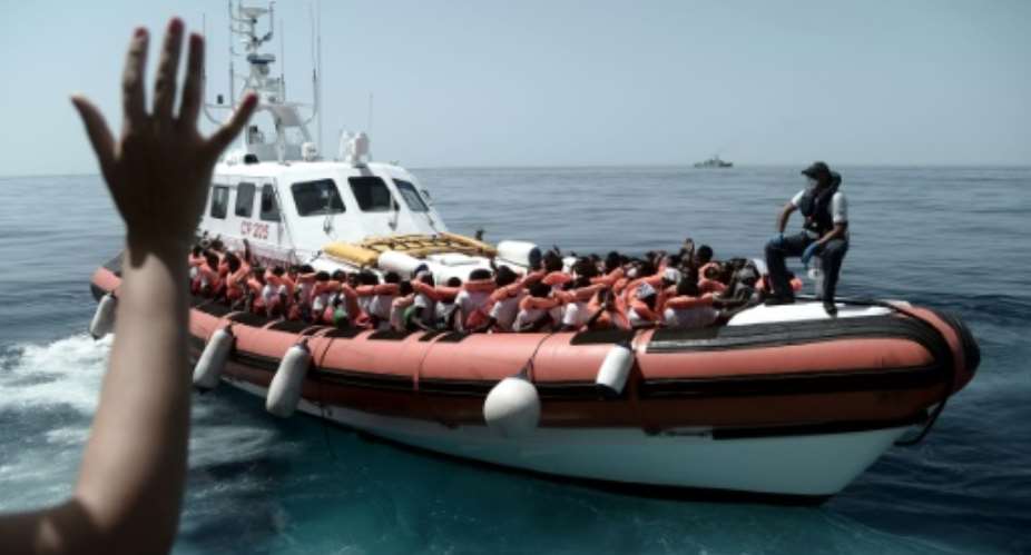 This handout picture from Medecins Sans Frontieres shows rescued migrants onboard an Italian coastguard ship following their transfer from the French NGO's ship Aquarius.  By Karpov MSFSOS MEDITERRANEEAFP