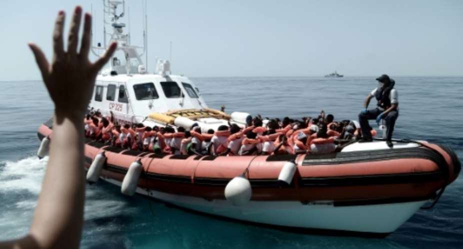 This handout picture from Medecins Sans Frontiers shows rescued migrants onboard an Italian coastguard ship following their transfer from the French NGO's ship Aquarius.  By Karpov MSFSOS MEDITERRANEEAFP