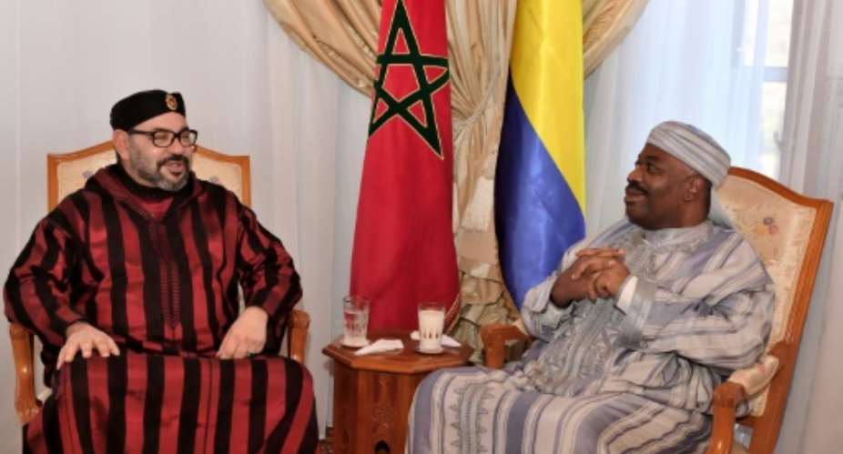 This handout picture provided by the Moroccan Royal Palace on December 3, 2018 shows Morocco's King Mohamed VI L visiting Gabon's President Ali Bongo at the military hospital in the capital Rabat..  By Handout Moroccan Royal PalaceAFP