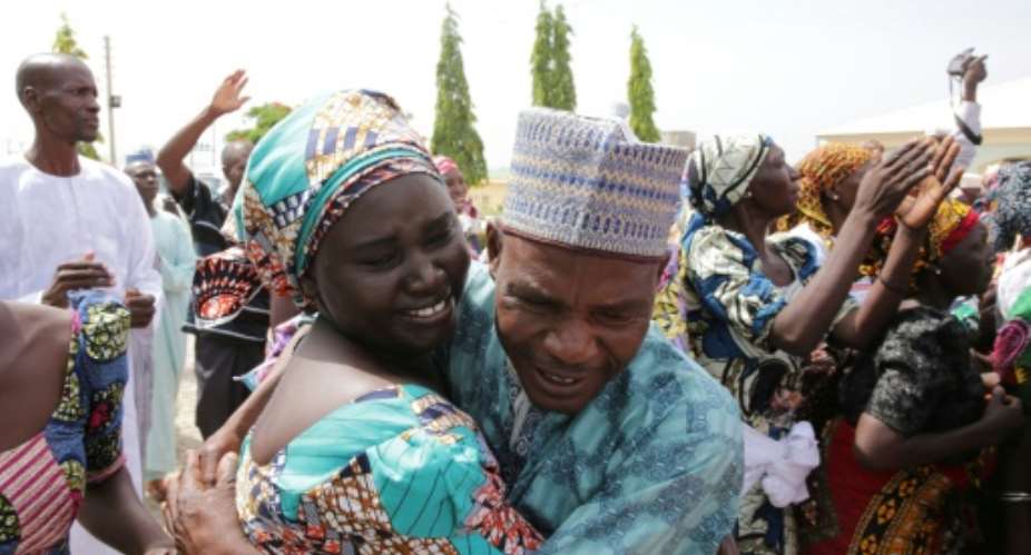 This handout picture released on May 20, 2017 by PGDBA  HND Mass Communication shows family members crying while being reunited with the released Chibok girls in Abuja  on May 20, 2017.  By SUNDAY AGHAEZE PGDBA  HND Mass CommunicationAFP