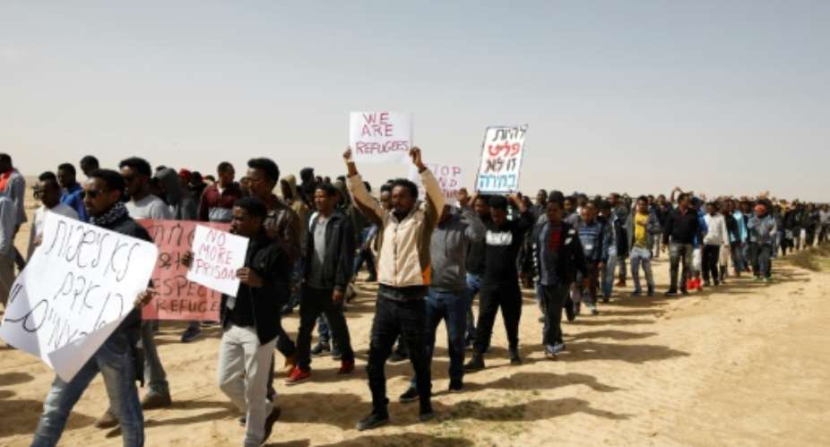 This photo taken on February 22, 2018 shows African migrants marching from the Holot detention centre to the Saharonim Prison, an Israeli detention facility for African asylum seekers.  By MENAHEM KAHANA AFPFile