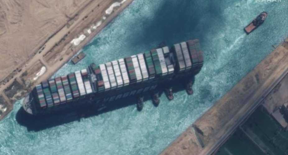 This satellite image released by Maxar Technologies shows the operation of tugboats dislodging the MV Ever Given container ship.  By - Satellite image 2021 Maxar TechnologiesAFP