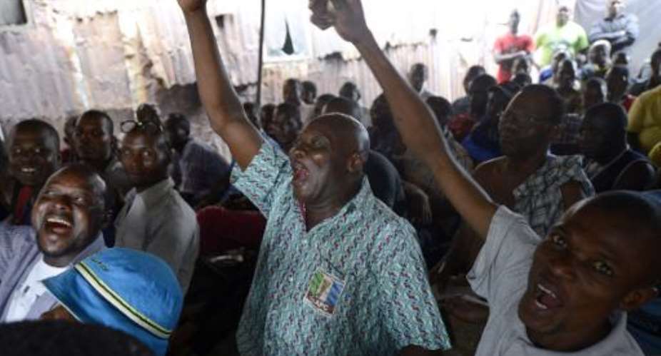 People react as partial results of the Nigerian presidential elections are released by the Independent National Electoral Commission indicating the main opposition APC presidential candidate is ahead, in Lagos on March 31, 2015.  By Pius Utomi Ekpei AFP