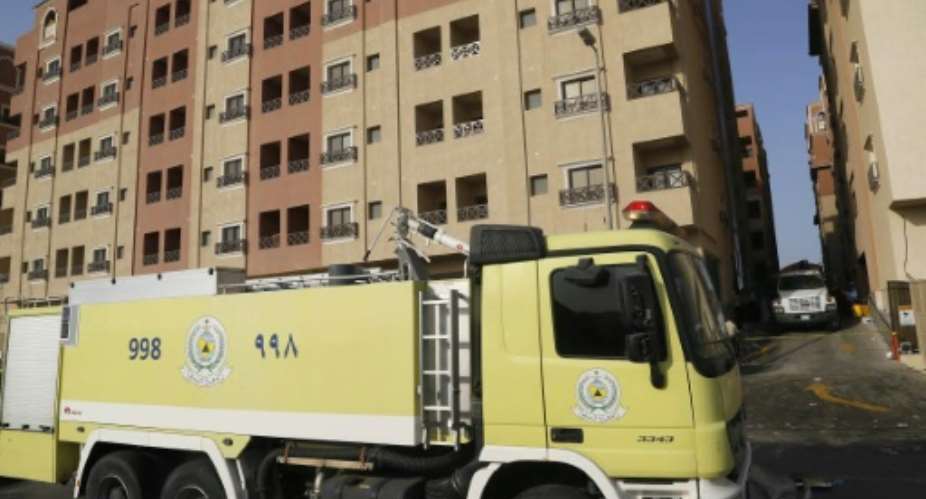 A Saudi firefighter truck is seen next to a residential complex housing employees of oil giant Saudi Aramco in Khobar on August 30, 2015 after a fire broke out there killing 11 people and wounding 219.  By  AFP