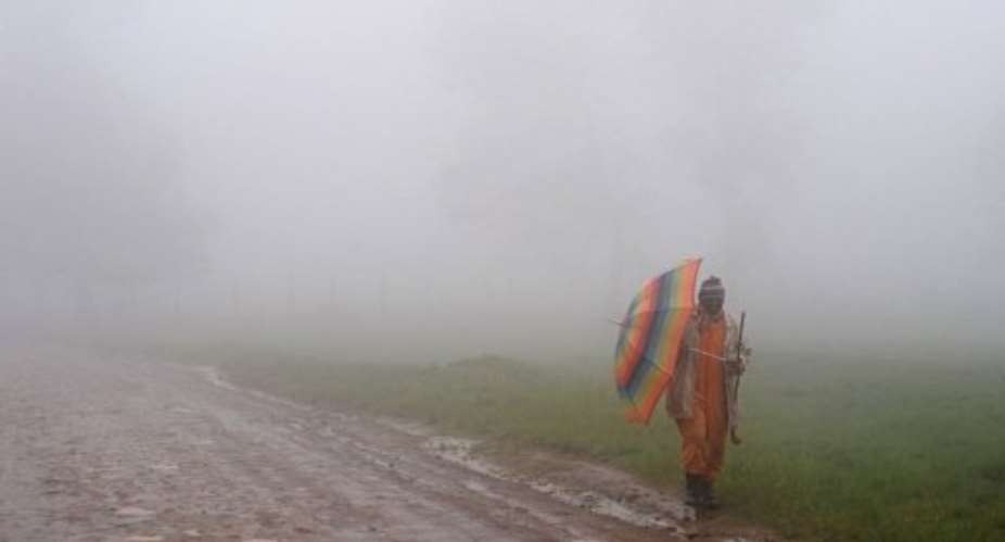 A South African tribesman walks in the rain in Umtata, in South Africa's Eastern Cape, in 2009.  By Alexander Joe AFPFile