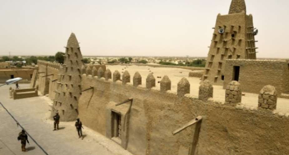 French soldiers of the 93rd Mountain Artillery Regiment and soldiers of the Malian Armed Forces patrol next to the Djingareyber Mosque on June 6, 2015 in Timbuktu.  By Philippe Desmazes (AFP/File)