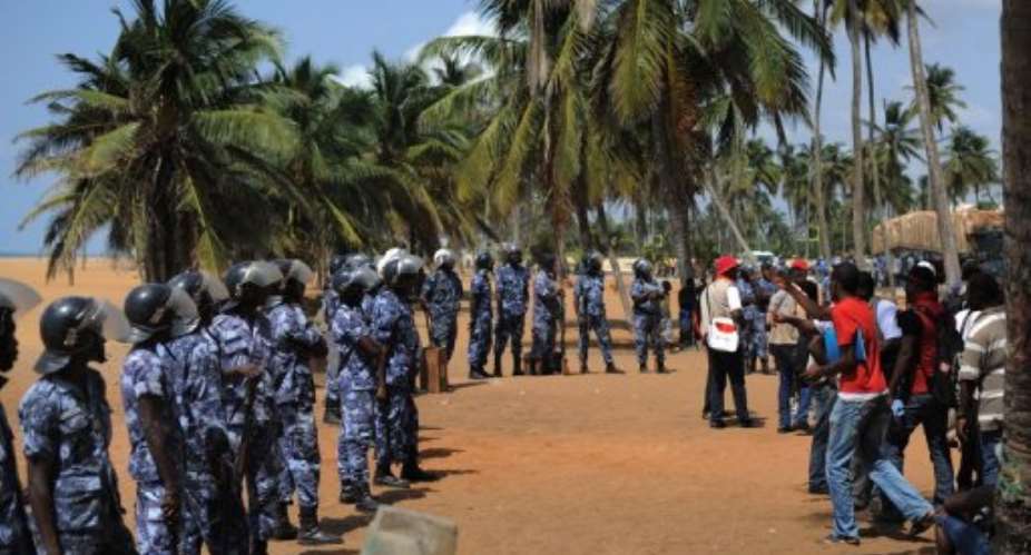 Opposition supporters face police officers after trying to hold a sit-in near the presidency in Lome on March 14, 2013.  By Daniel Hayduk AFPFile