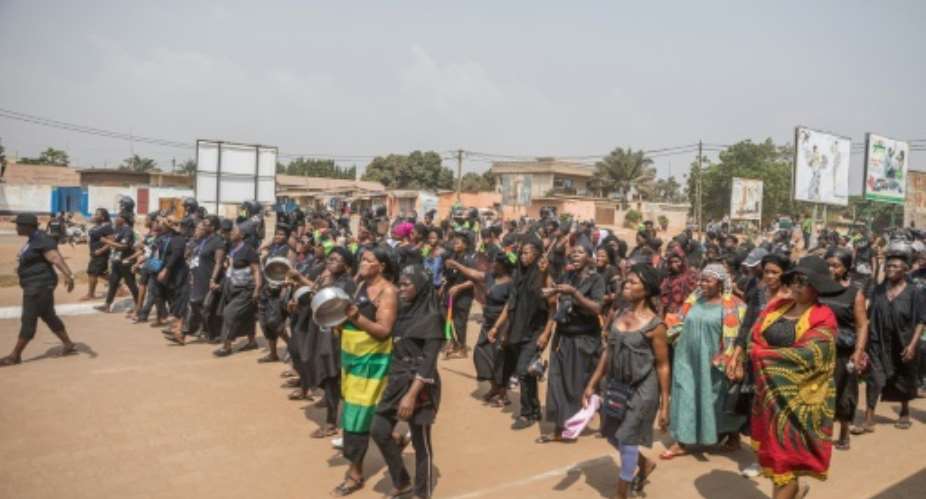 Togolese women dressed in black, some banging on pots, are pictured protesting in the capital city of Lome during a protest rally against Togo's president on January 20, 2018.  By Yanick Folly AFPFile