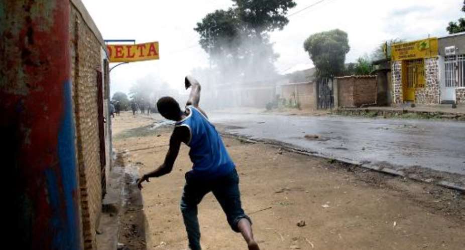 A protester throws stones at police during street battle in Mugasa district of Bujumbura, Burundi, on May 4, 2015.  By Aymeric Vincenot AFP