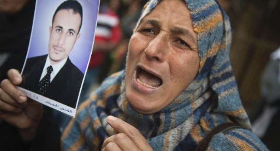 An Egyptian woman holding the portrait of a relative reacts outisde the court that sentenced 682 alleged Islamists and a Muslim Brotherhood leader to death on April 28, 2014 in the southern city of Minya.  By Khaled Desouki AFP
