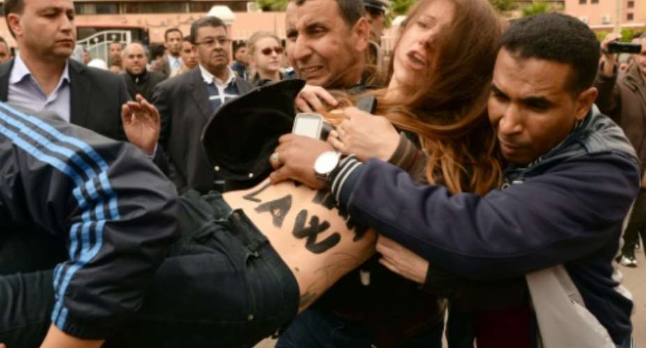 Undercover Moroccan police arrest a FEMEN activist outside the court in the central city of Beni Mellal on April 11, 2016.  By Fadel Senna AFP