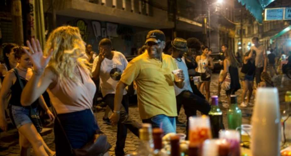 Tourists and locals dance to funk music in Pedra do Sal, located in downtown Rio near the port, where many slaves went soon after arriving on ships from Africa.  By MAURO PIMENTEL AFP
