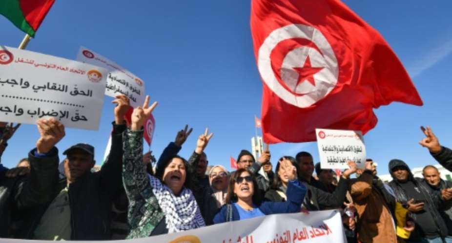 Trade unionists shout slogans as they take to the streets of Tunis to protest against proposed legislation that will grant the government sweeping powers over NGOs.  By FETHI BELAID AFP