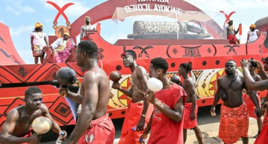 Traditional groups accompany the Djidji Ayokwe talking drum back to its village of origin.  By Issouf SANOGO (AFP)