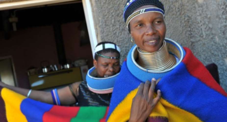 Traditional Ndebele dress includes multicoloured shawls worn around the shoulders for both men and women.  By ALEXANDER JOE AFPFile